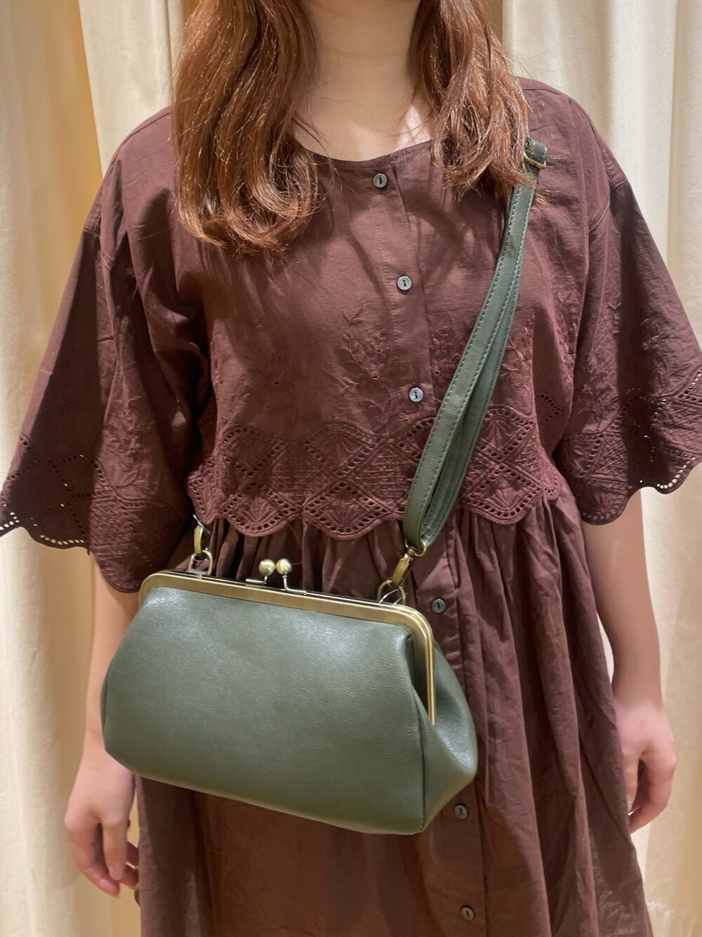 ブラウン系のチュニック、グリーン系のハンドバッグ、ベージュ系のその他パンツを着用したレディースの夏コーディネートの4枚目の写真