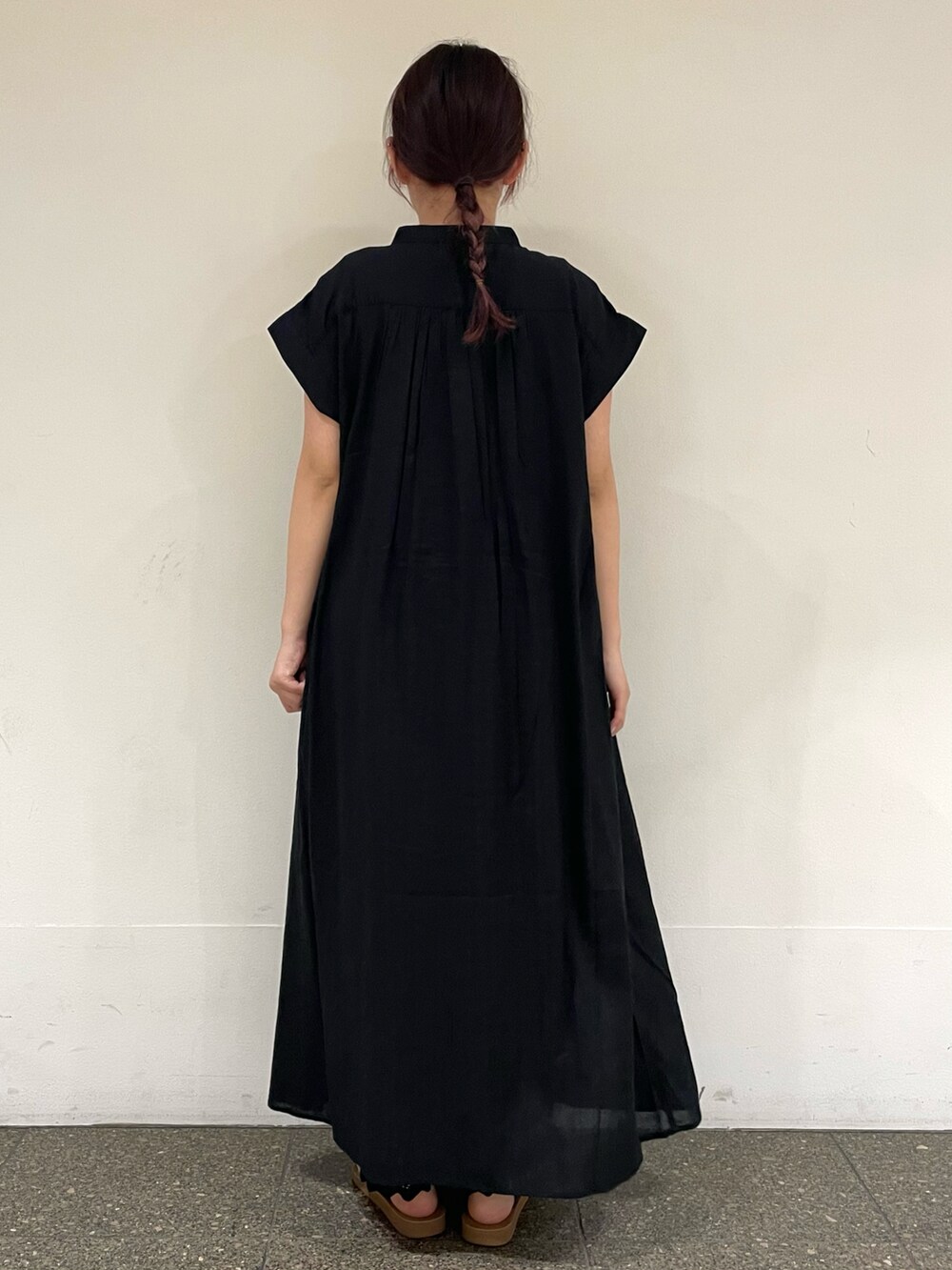 ブラウン系のサンダル、ブラック系のワンピースを着用したレディースの秋コーディネートの4枚目の写真