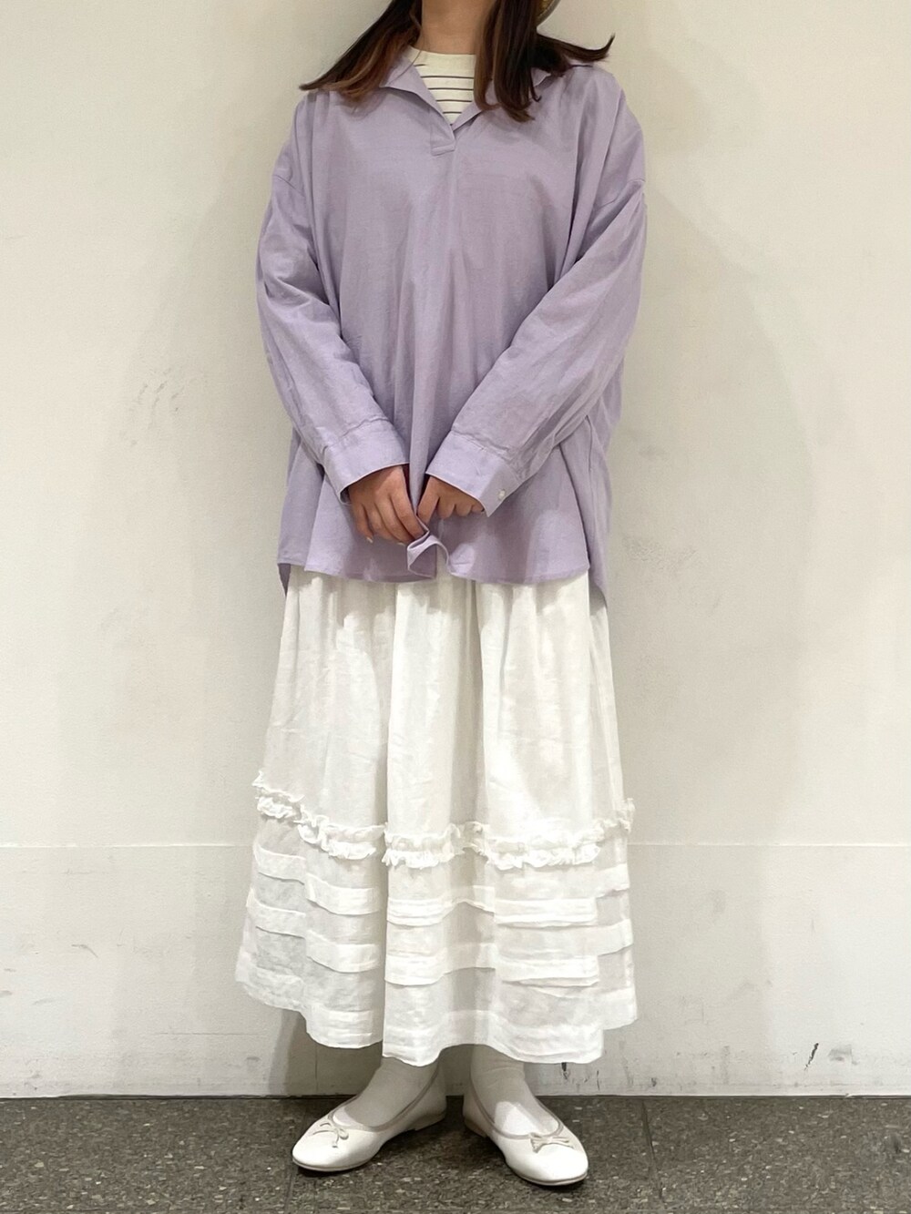 ホワイト系のパンプス、パープル系のチュニック、ホワイト系のスカートを着用したレディースの春コーディネートの2枚目の写真