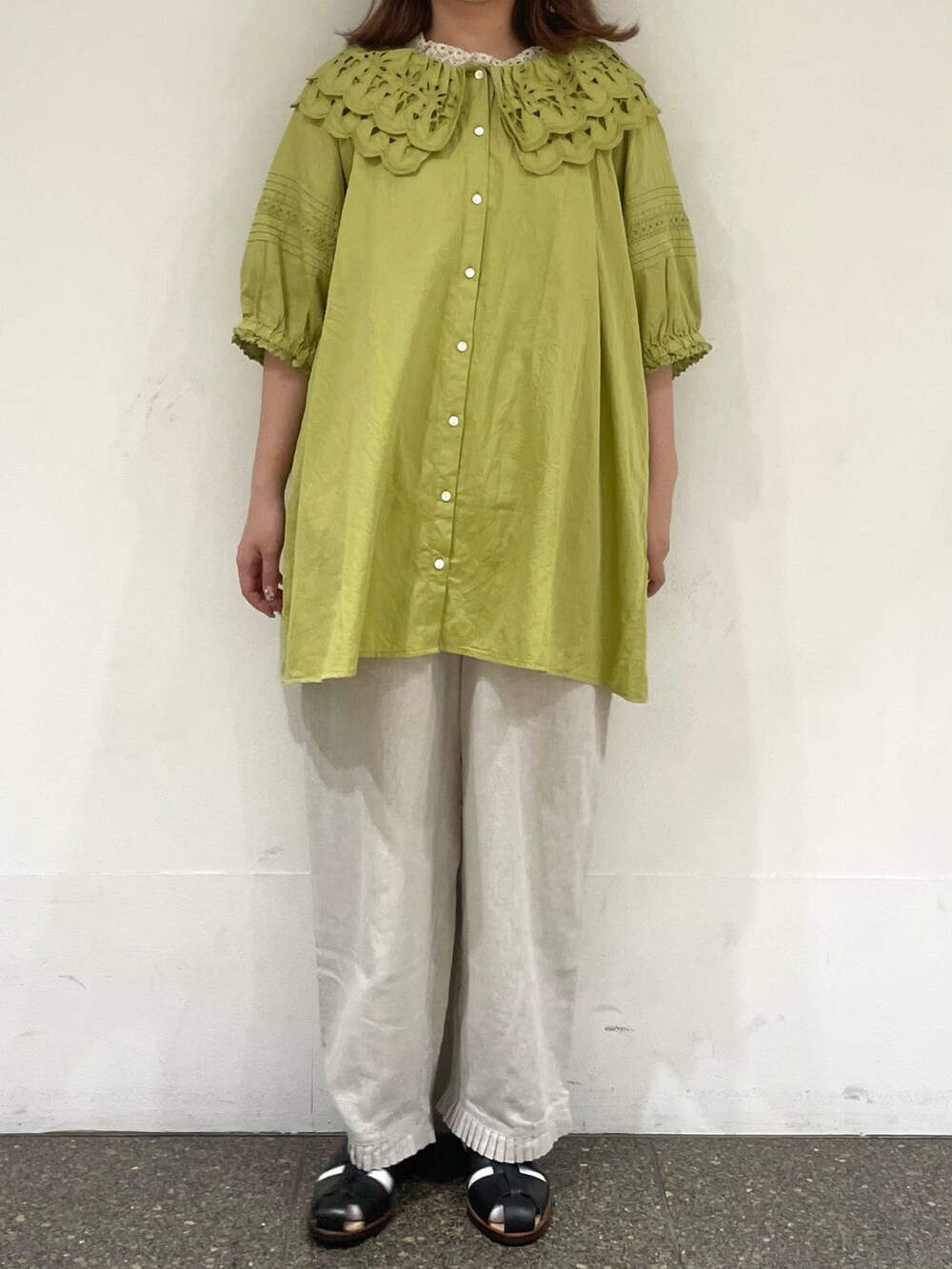 ベージュ系のタンクトップ、グリーン系のチュニック、ホワイト系のその他パンツを着用したレディースの夏コーディネートの2枚目の写真