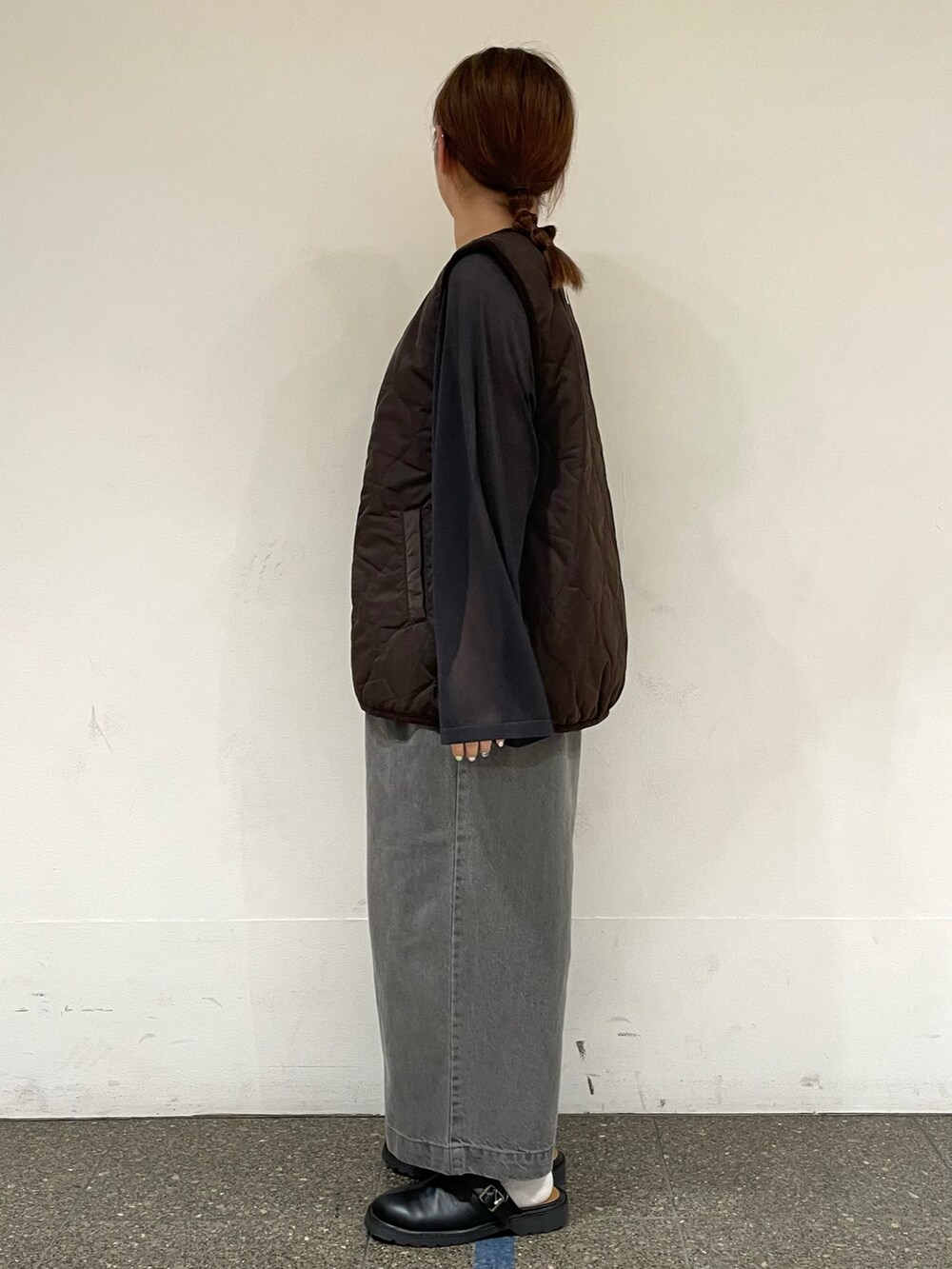 ブラック系のニット/セーター、ブラウン系のベスト、グレー系のデニムパンツを着用したレディースの秋コーディネートの3枚目の写真