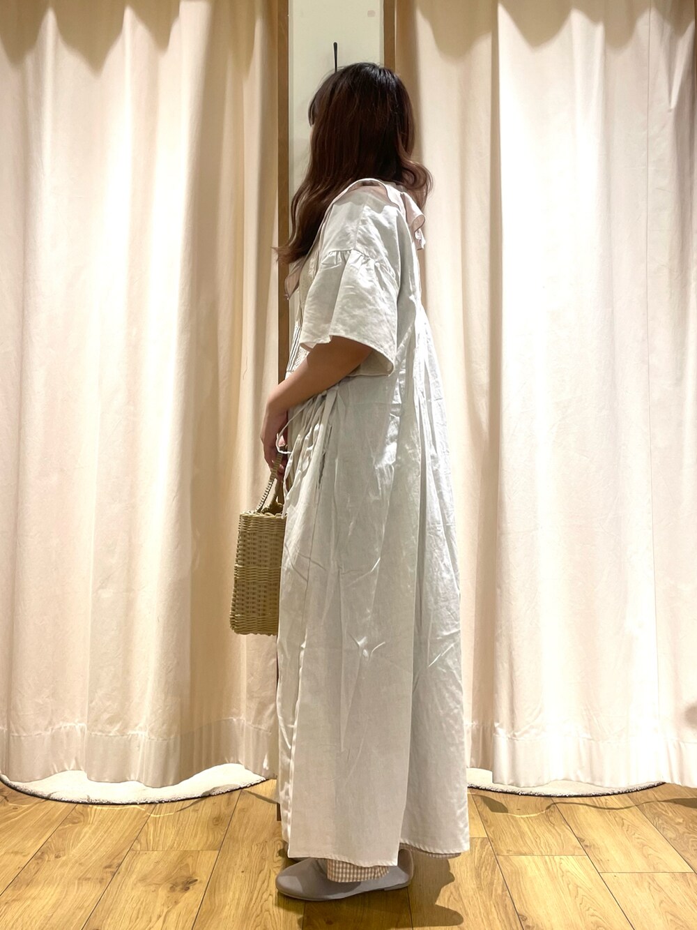 ホワイト系のワンピース、ベージュ系のスカート、ベージュ系のトートバッグを着用したレディースの夏コーディネートの2枚目の写真