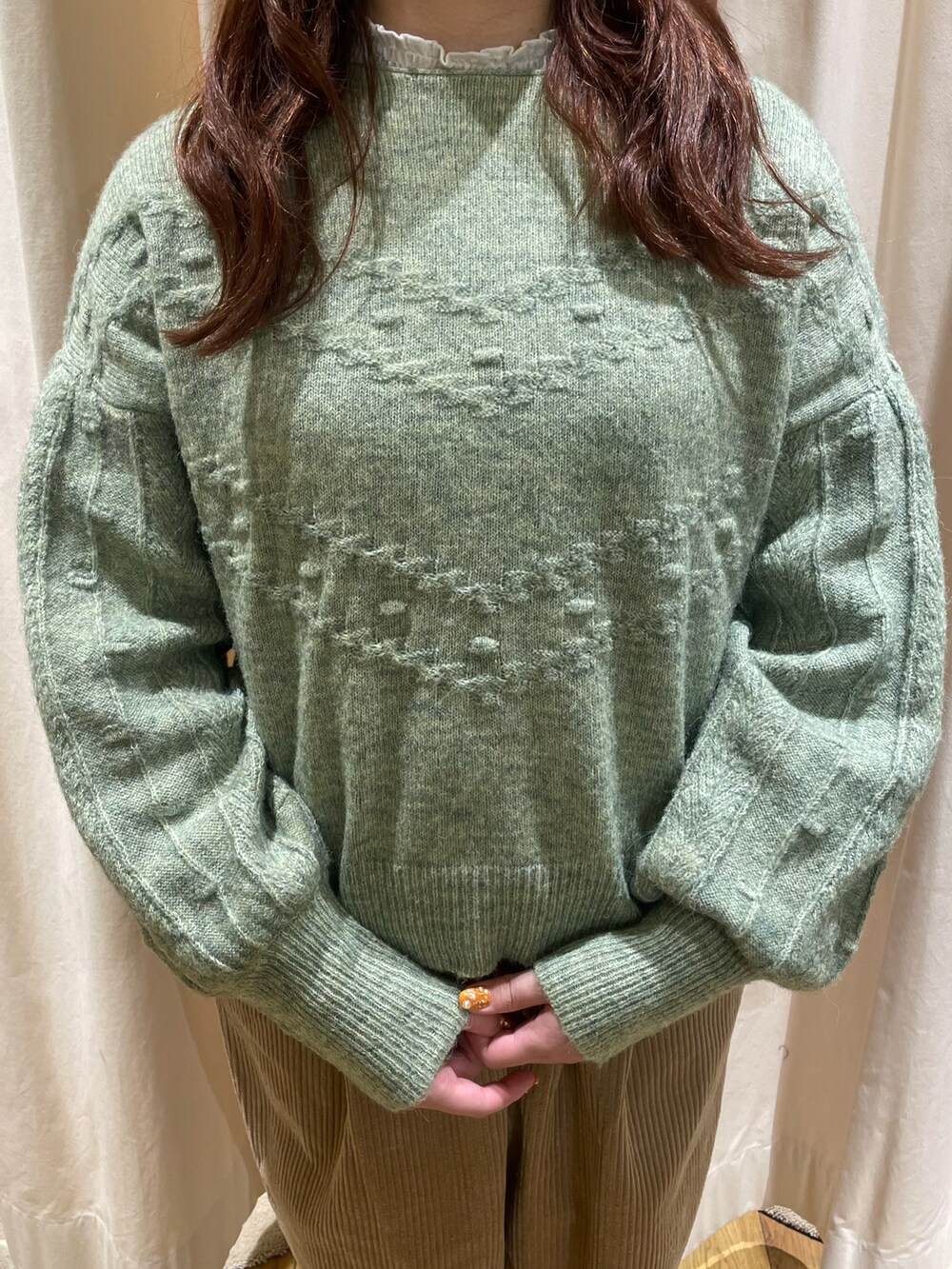 ホワイト系のシャツ/ブラウス、グリーン系のニット/セーター、ベージュ系のその他パンツを着用したレディースの冬コーディネートの4枚目の写真