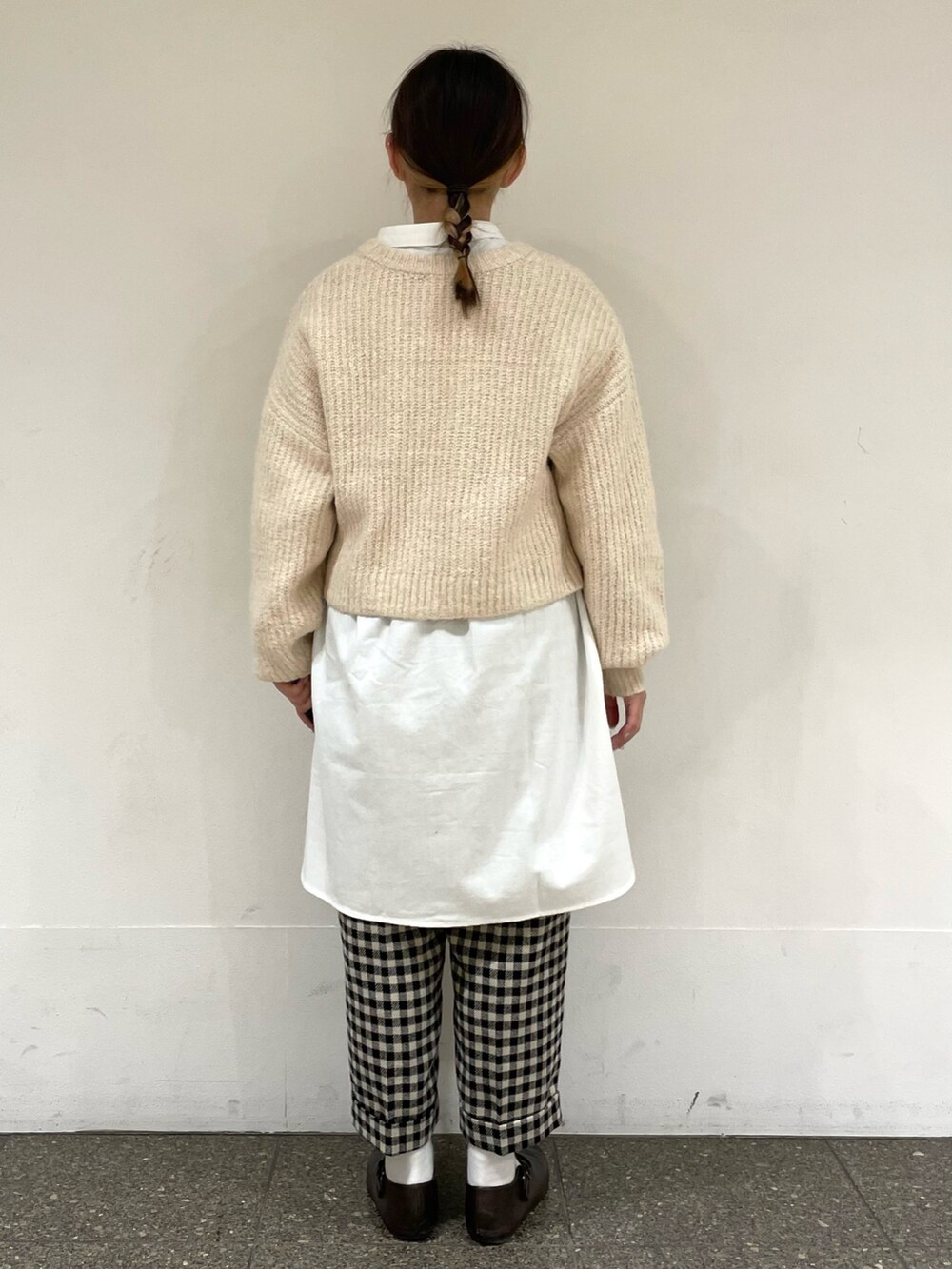 ホワイト系のチュニック、ブラウン系のドレスシューズ、ホワイト系のカーディガン/ボレロを着用したレディースの冬コーディネートの4枚目の写真