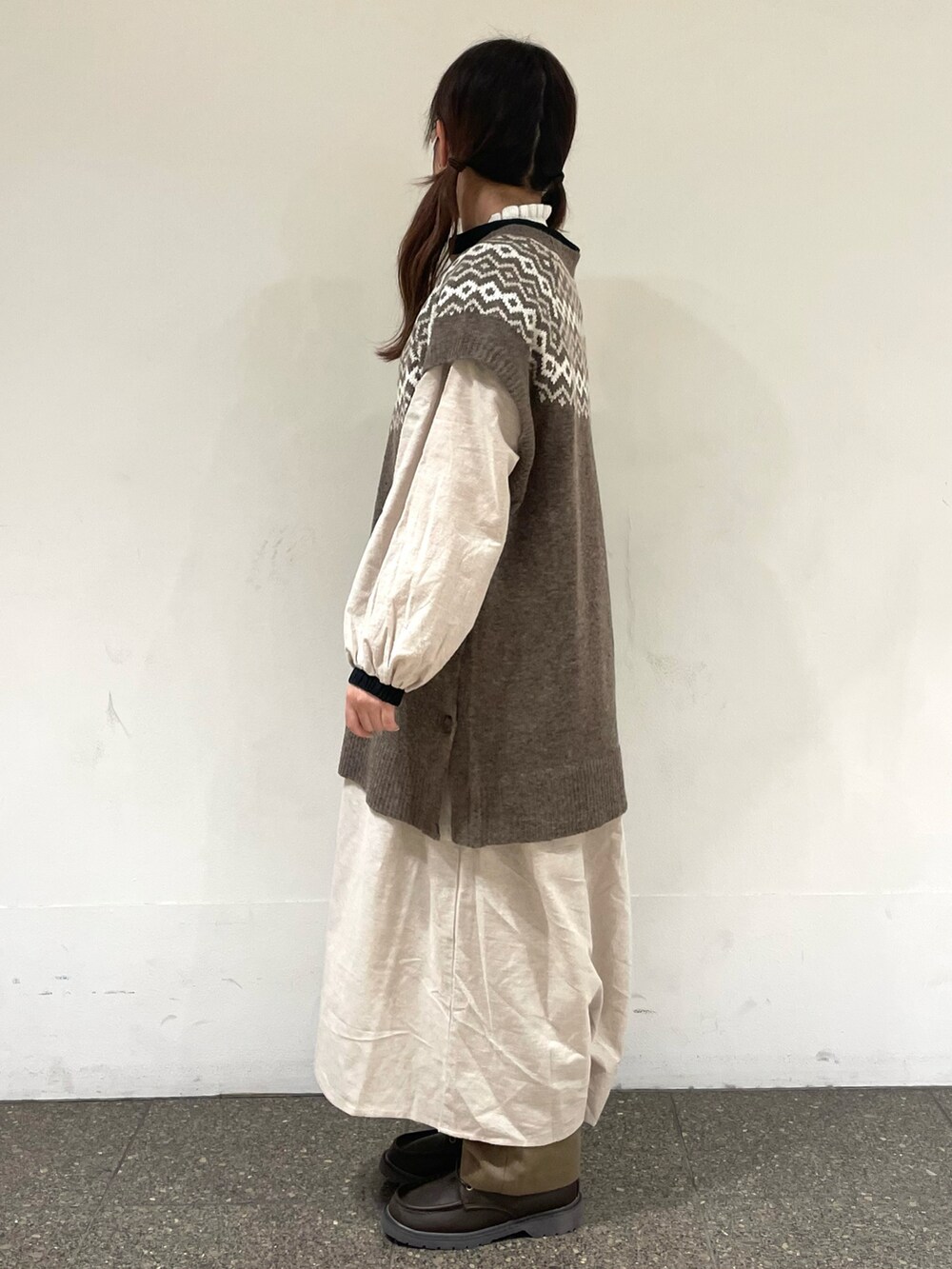 ベージュ系のワンピース、ブラウン系のベスト、ブラウン系のその他パンツを着用したレディースの冬コーディネートの2枚目の写真