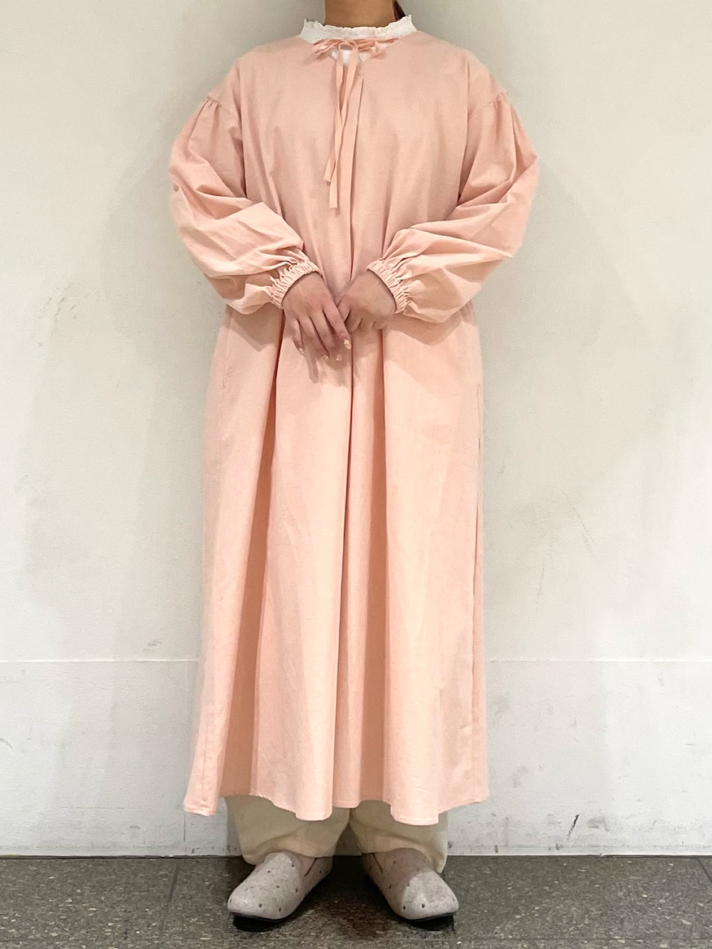 ベージュ系のドレスシューズ、ピンク系のワンピース、ホワイト系のその他パンツを着用したレディースの冬コーディネートの2枚目の写真