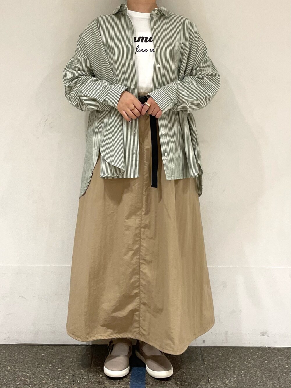 ホワイト系のTシャツ/カットソー、グリーン系のシャツ/ブラウス、ブラウン系のスニーカーを着用したレディースの秋コーディネートの2枚目の写真