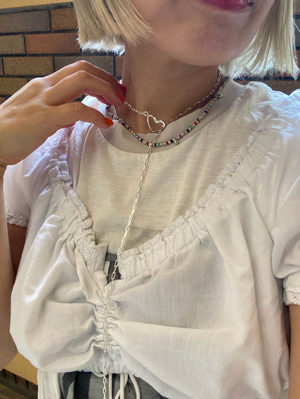 ブルー系のデニムパンツ、ホワイト系のトップス、ホワイト系のTシャツ/カットソーを着用したレディースの夏コーディネートの2枚目の写真
