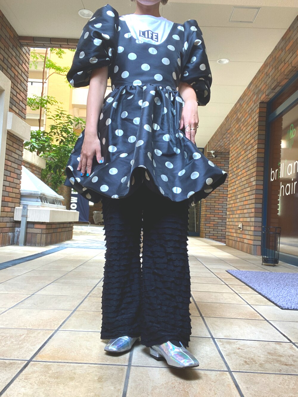 グリーン系のパンツ、ブラック系のワンピース、ホワイト系のTシャツ/カットソーを着用したレディースの夏コーディネートの2枚目の写真