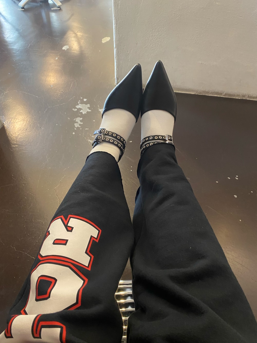 レッド系のニット/セーター、ブラック系のスカート、ブラック系のスウェットパンツを着用したレディースの冬コーディネートの2枚目の写真