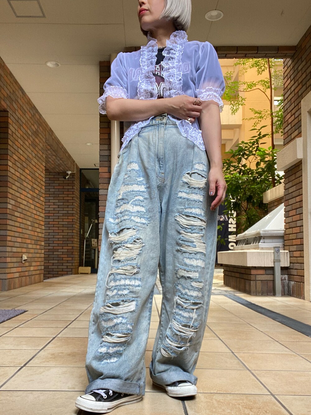 ホワイト系のトップス、ブルー系のデニムパンツを着用したレディースの夏コーディネートの2枚目の写真