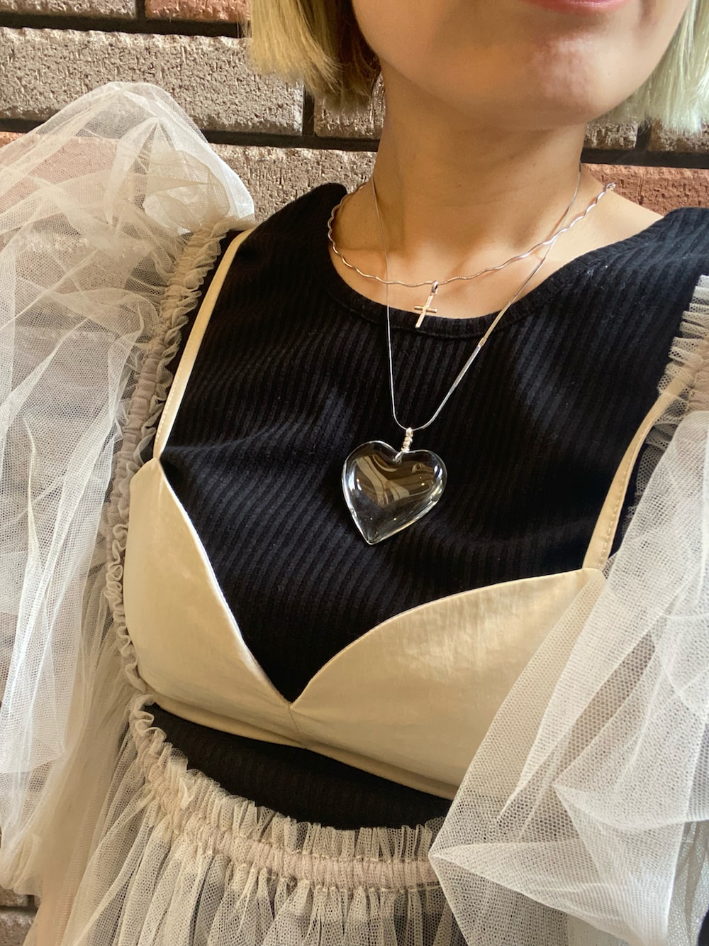 ベージュ系のベスト、ブラック系のTシャツ/カットソーを着用したレディースの春コーディネートの2枚目の写真