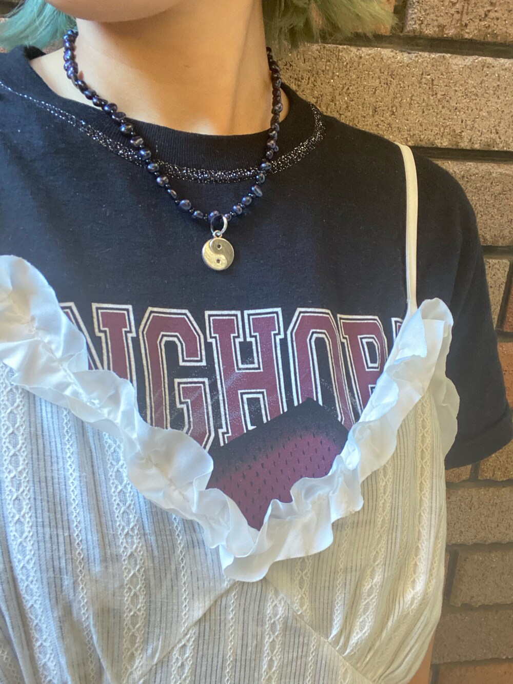 ホワイト系のチュニック、グリーン系のパンツを着用したレディースの夏コーディネートの2枚目の写真