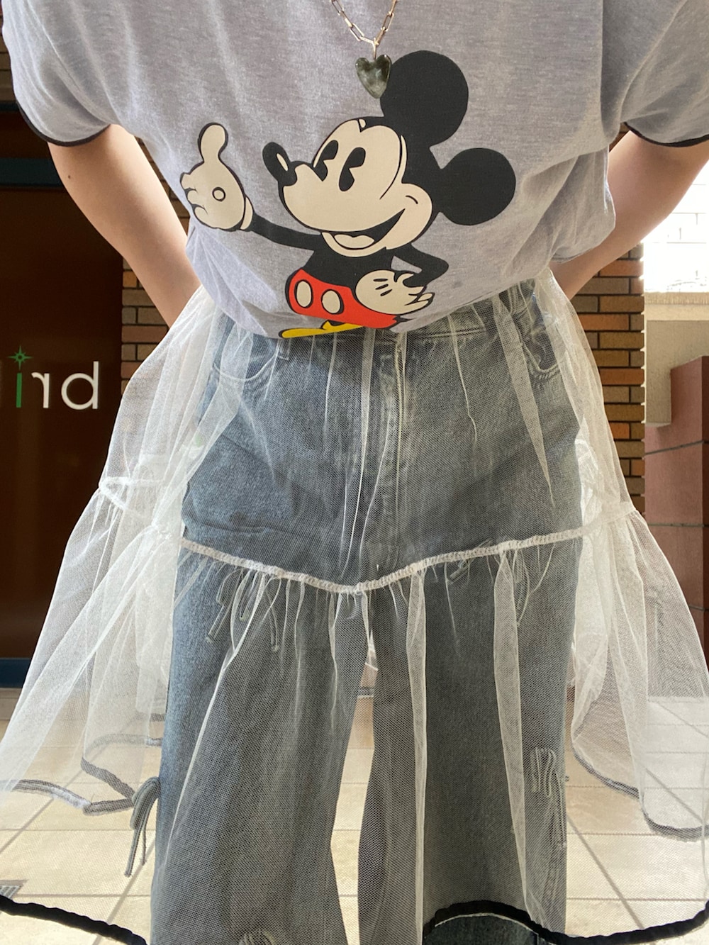 グレー系のTシャツ/カットソー、ホワイト系のスカート、ブルー系のデニムパンツを着用したレディースの夏コーディネートの2枚目の写真