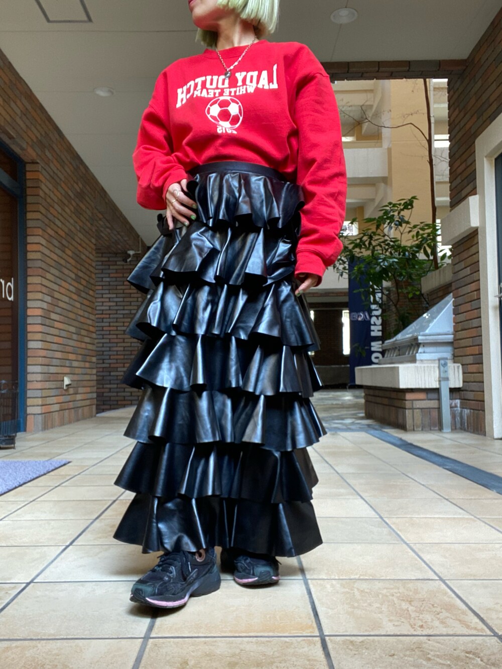 ブラック系のスカート、ホワイト系のムートンコート、レッド系のスウェットを着用したレディースの冬コーディネートの2枚目の写真