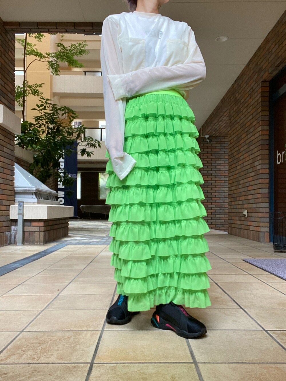 ホワイト系のTシャツ/カットソー、ピンク系のトップス、グリーン系のスカートを着用したレディースの秋コーディネートの2枚目の写真