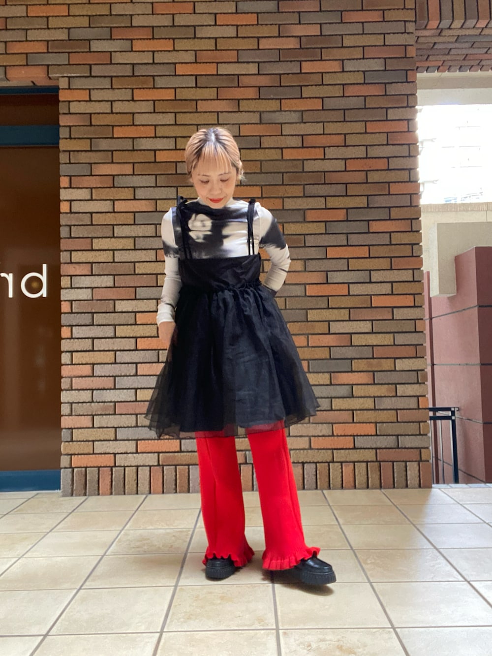 グレー系のテーラードジャケット、レッド系のその他パンツ、ブラック系のローファーを着用したレディースの秋コーディネートの2枚目の写真