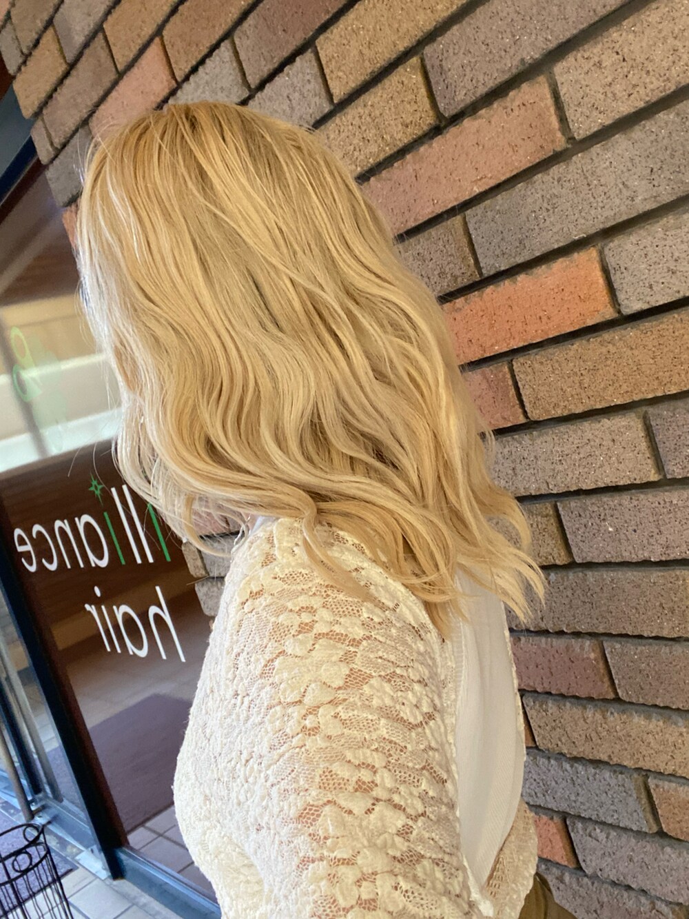 ホワイト系のトップス、ベージュ系のチノパンツ、ブラック系のパンプスを着用したレディースの春コーディネートの2枚目の写真