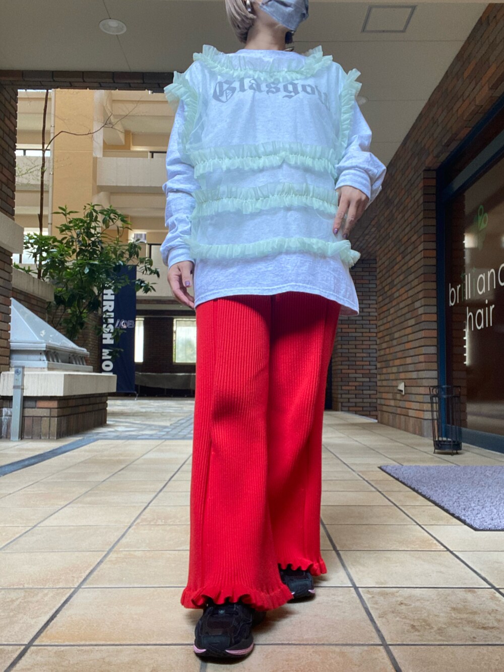 グレー系のTシャツ/カットソー、グリーン系のベスト、レッド系のその他パンツを着用したレディースの春コーディネートの2枚目の写真