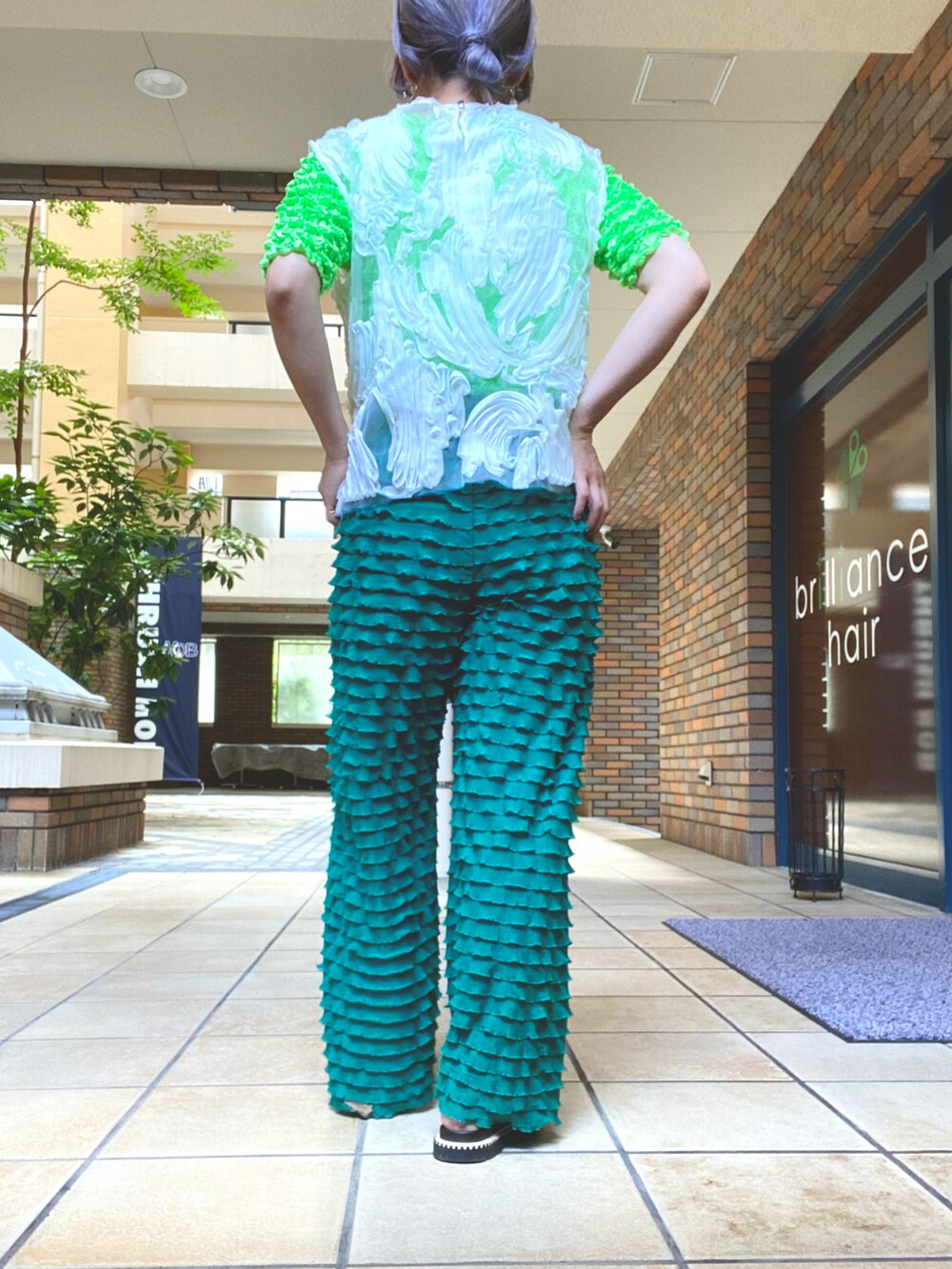 ホワイト系のその他トップス、グリーン系のパンツ、ブラック系のサンダルを着用したレディースの夏コーディネートの2枚目の写真