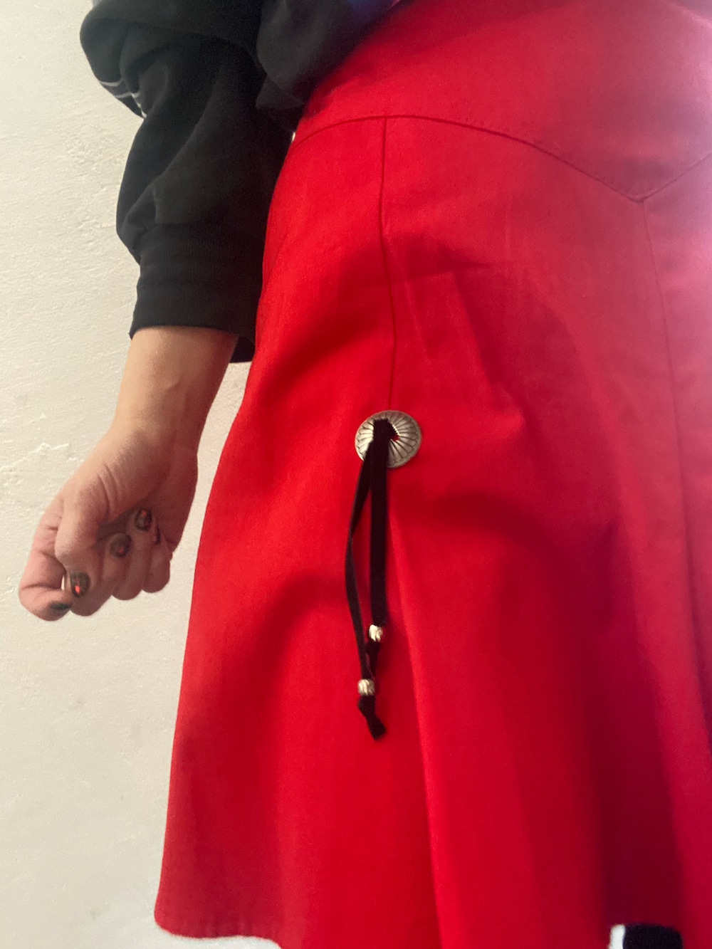 ブラック系のスウェット、レッド系のスカート、ブラック系のパンツを着用したレディースの冬コーディネートの2枚目の写真