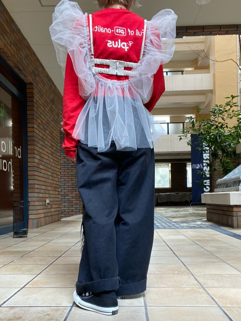 ブラック系のパンツ、ベージュ系のベスト、レッド系のTシャツ/カットソーを着用したレディースの春コーディネートの2枚目の写真