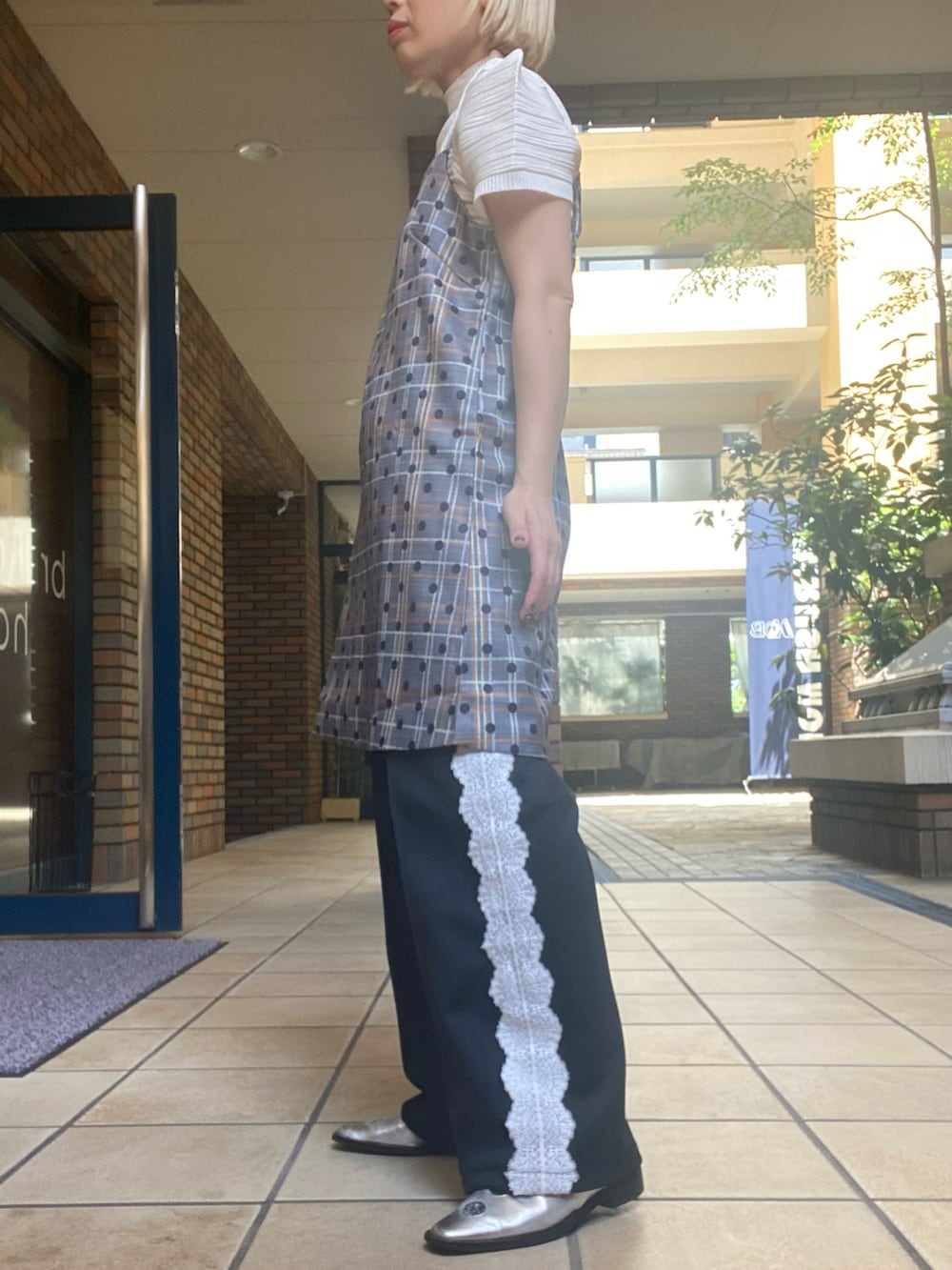 グレー系のチュニック、ホワイト系のその他トップス、ブラック系のその他パンツを着用したレディースの春コーディネートの2枚目の写真