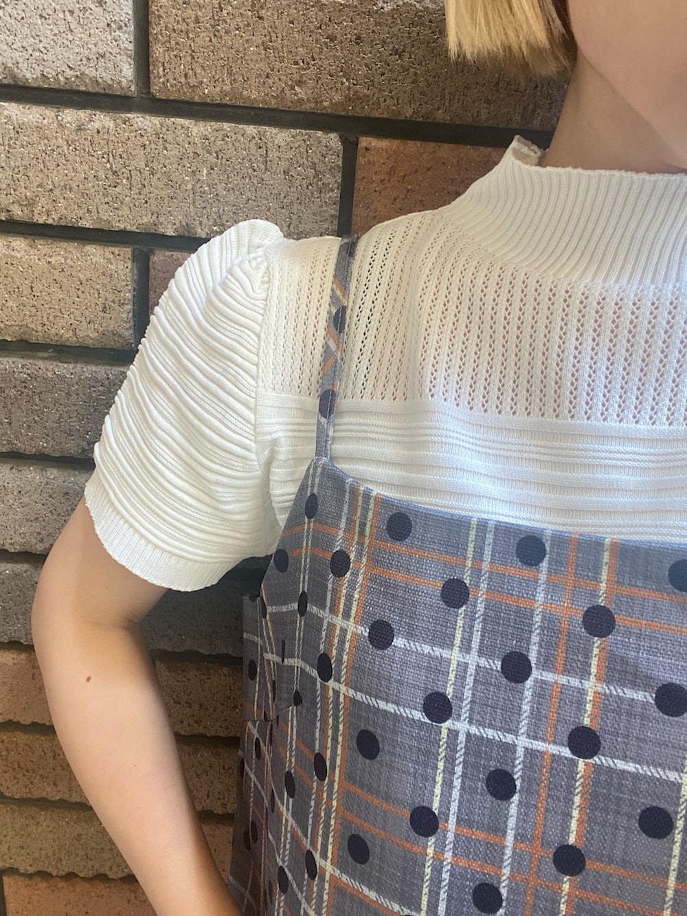 グレー系のチュニック、ホワイト系のその他トップス、ブラック系のその他パンツを着用したレディースの春コーディネートの3枚目の写真