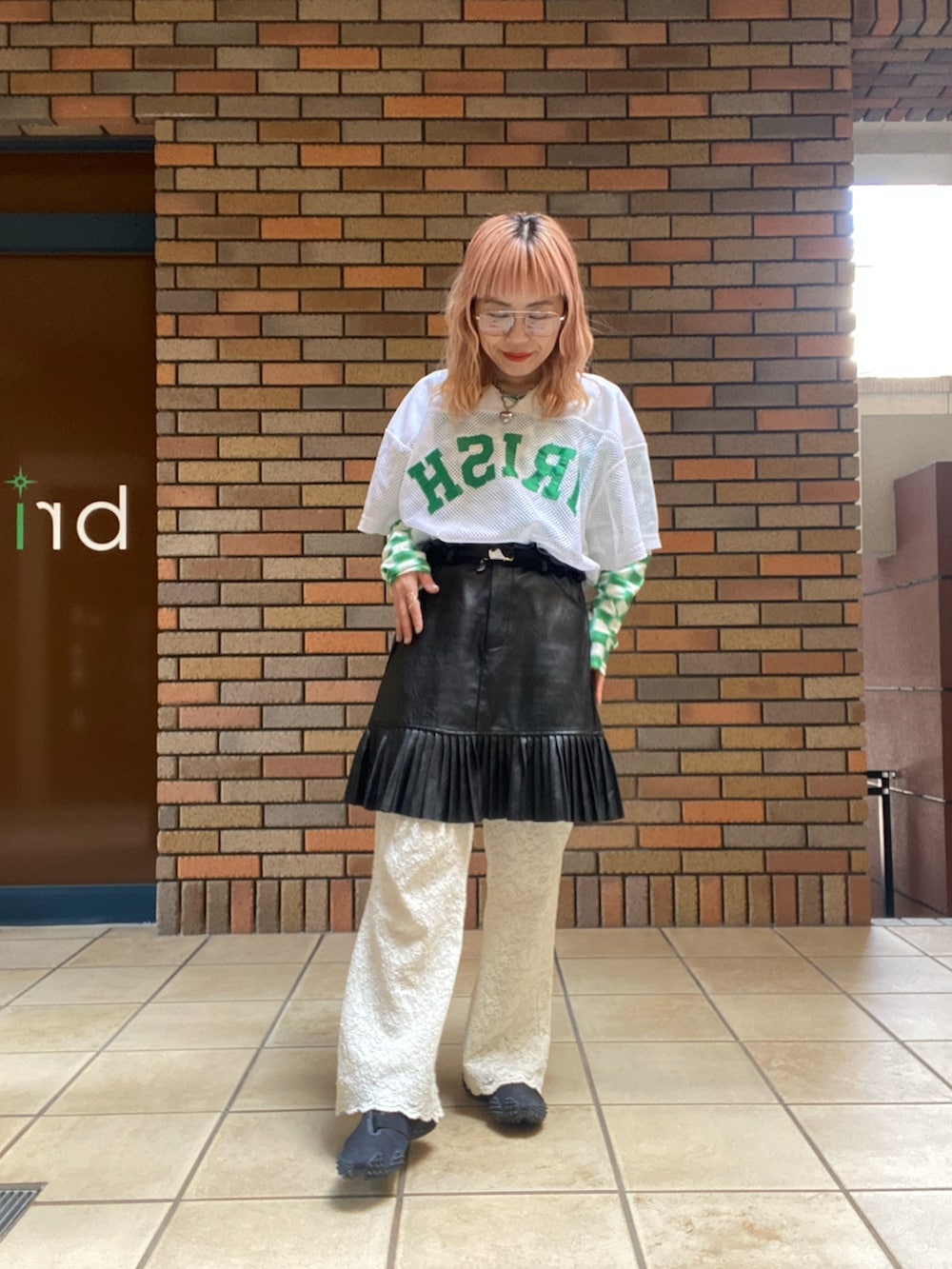 ブラック系のスニーカー、ホワイト系のトップス、グリーン系のトップスを着用したレディースの春コーディネートの2枚目の写真