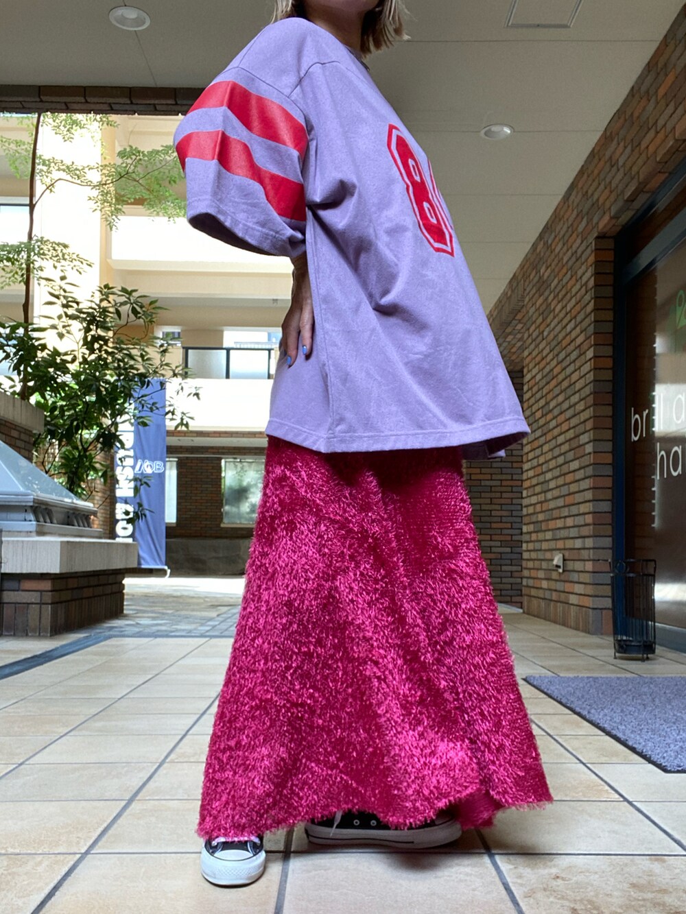 ピンク系のスカート、ピンク系のトップスを着用したレディースの夏コーディネートの2枚目の写真