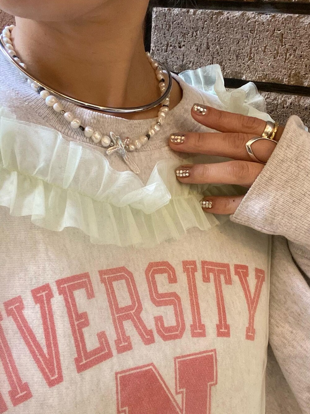 グリーン系のベスト、レッド系のパンツを着用したレディースの秋コーディネートの2枚目の写真