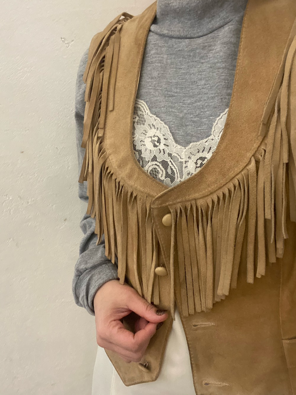 ベージュ系のベスト、グレー系のトップス、ホワイト系のワンピース/ドレスを着用したレディースの冬コーディネートの2枚目の写真