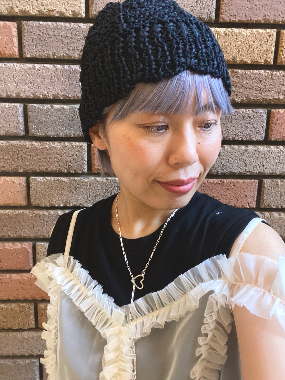 ホワイト系のキャミソール、ブラック系のタンクトップ、その他のスカートを着用したレディースの夏コーディネートの2枚目の写真