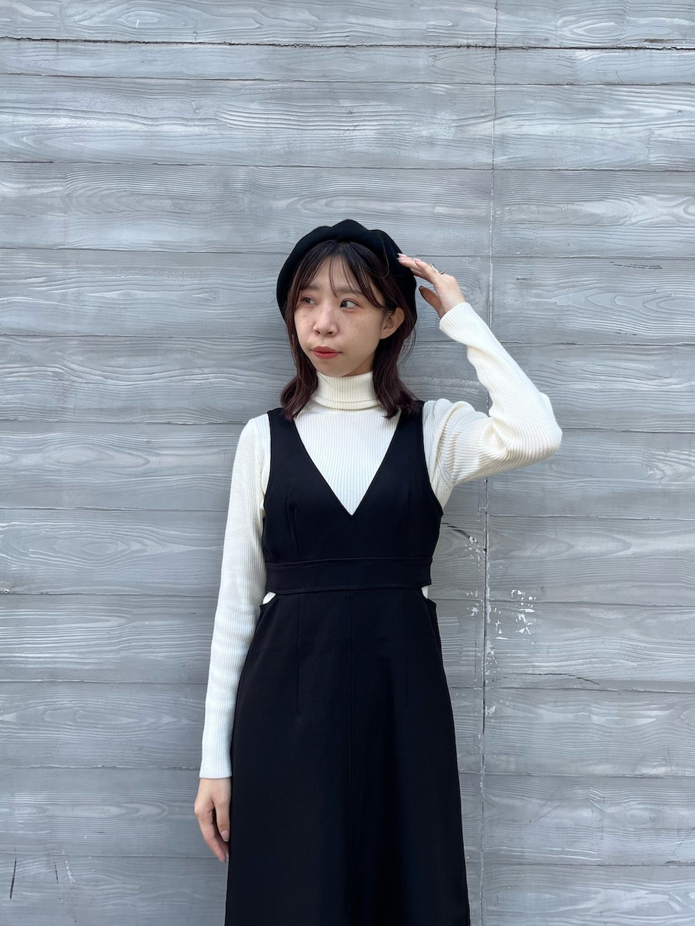 ホワイト系のニット/セーター、ブラック系のワンピース、ブラック系のブーツを着用したレディースの秋コーディネートの4枚目の写真