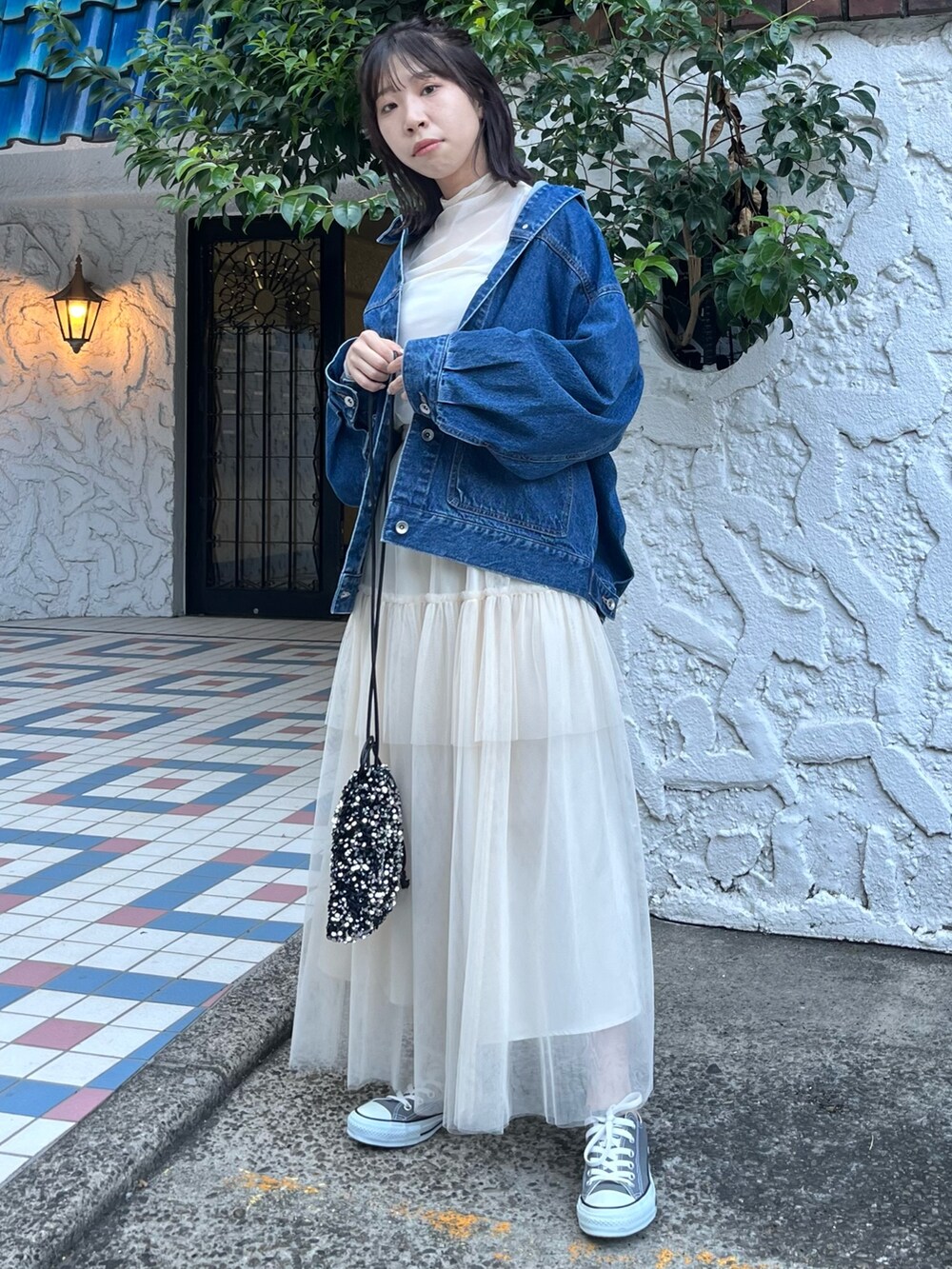 ホワイト系のスカート、ブルー系のデニムジャケット、ホワイト系のTシャツ/カットソーを着用したレディースの秋コーディネートの2枚目の写真