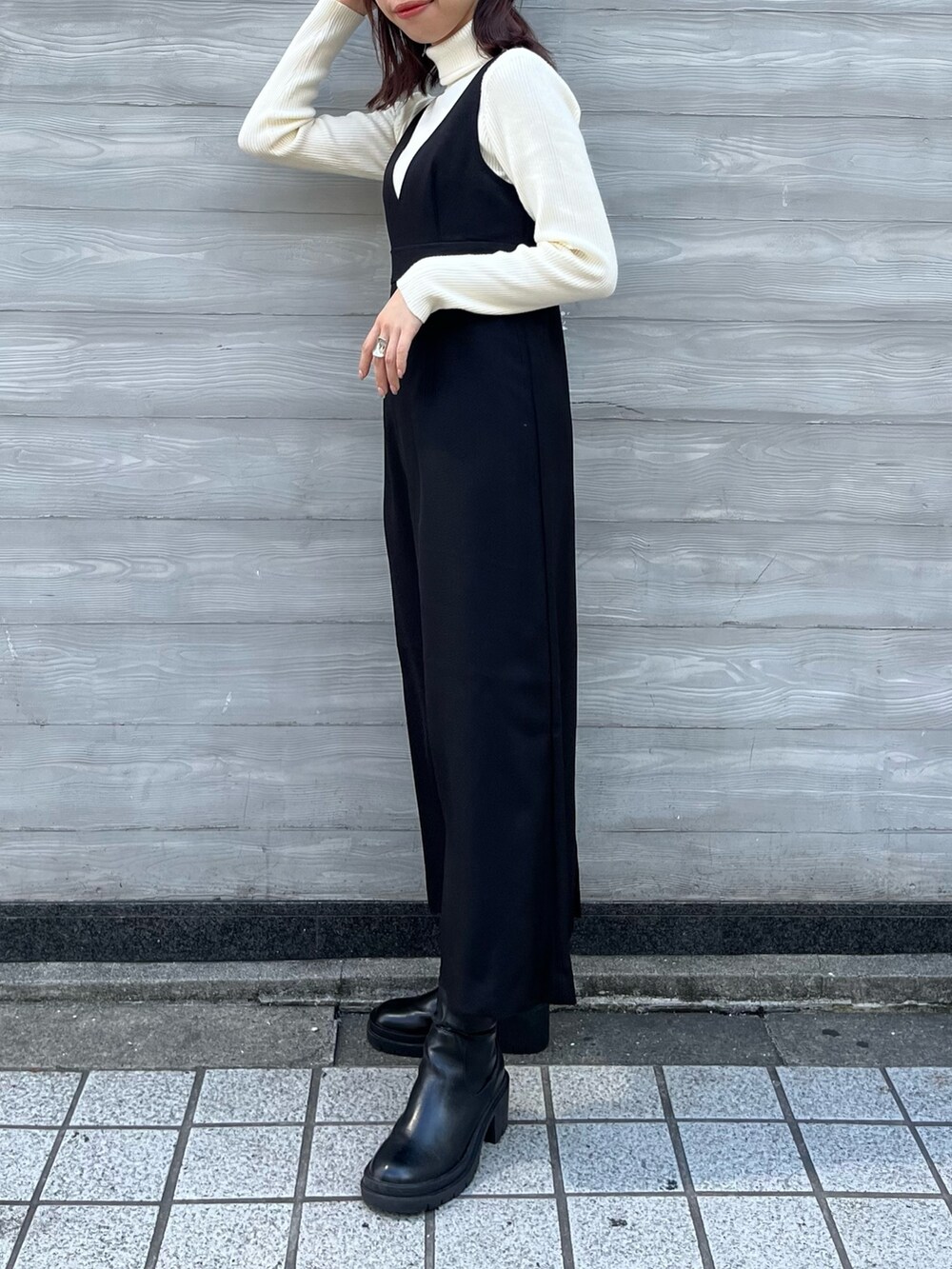 ホワイト系のニット/セーター、ブラック系のワンピース、ブラック系のブーツを着用したレディースの秋コーディネートの2枚目の写真