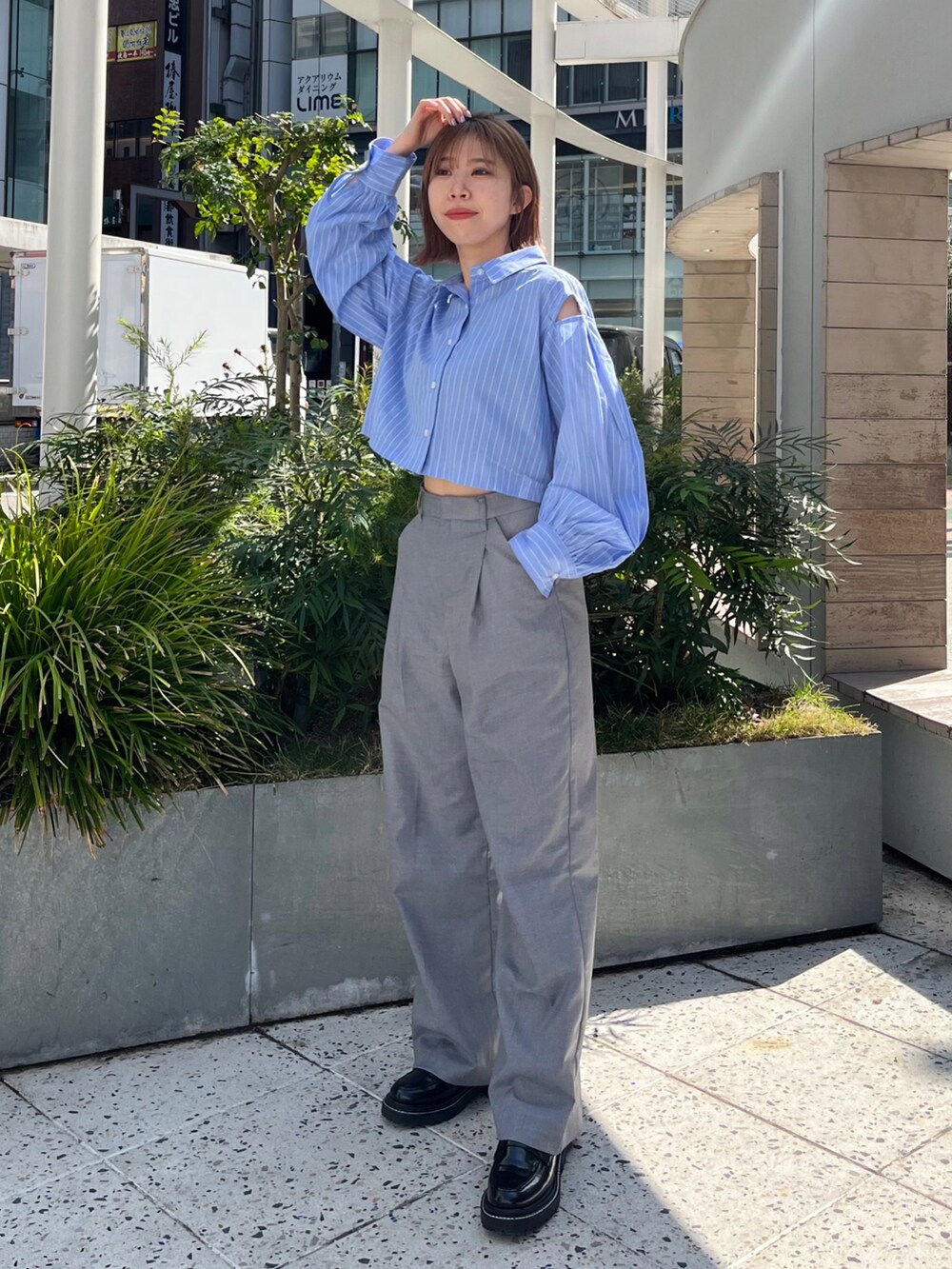 ブルー系のシャツ/ブラウス、グレー系のその他パンツ、ブラック系のローファーを着用したレディースの春コーディネートの2枚目の写真