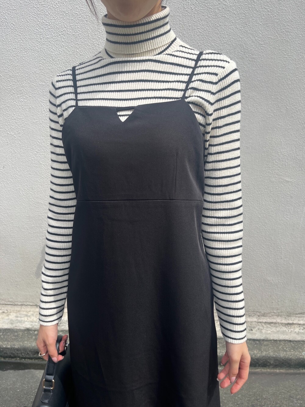 ブラック系のワンピース、ホワイト系のニット/セーター、ブラック系のブーツを着用したレディースの秋コーディネートの3枚目の写真