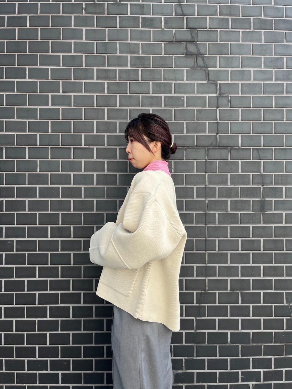 ホワイト系のカーディガン/ボレロ、グレー系のスラックス、ピンク系のニット/セーターを着用したレディースの秋コーディネートの4枚目の写真