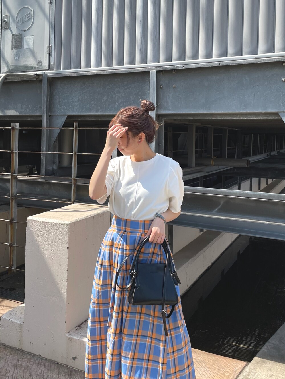 ブルー系のスカート、ブラック系のショルダーバッグ、ホワイト系のTシャツ/カットソーを着用したレディースの夏コーディネートの3枚目の写真