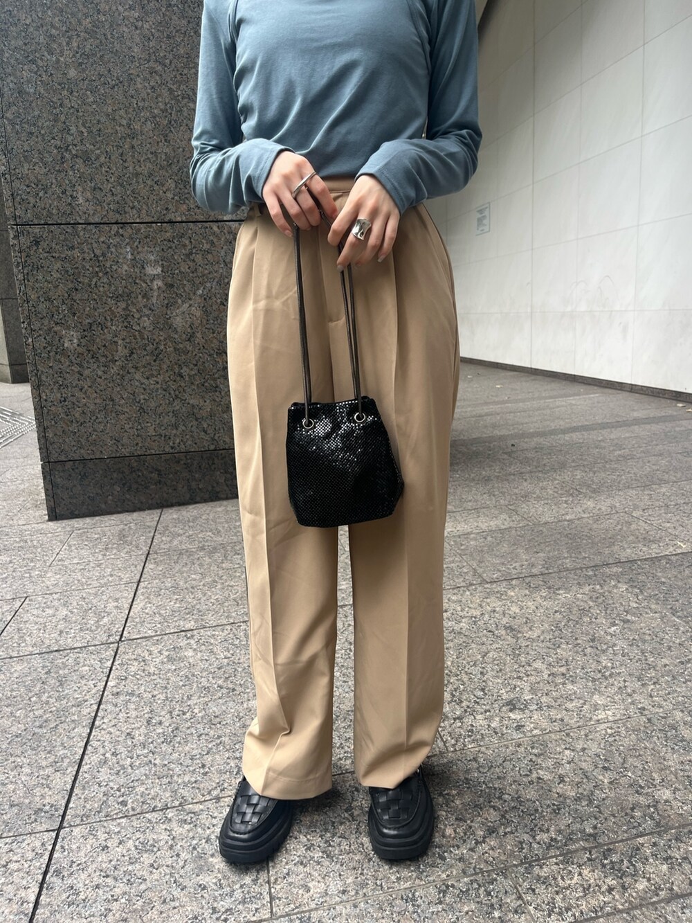 ブルー系のTシャツ/カットソー、ベージュ系のスラックス、ブラック系のバッグを着用したレディースの秋コーディネートの5枚目の写真