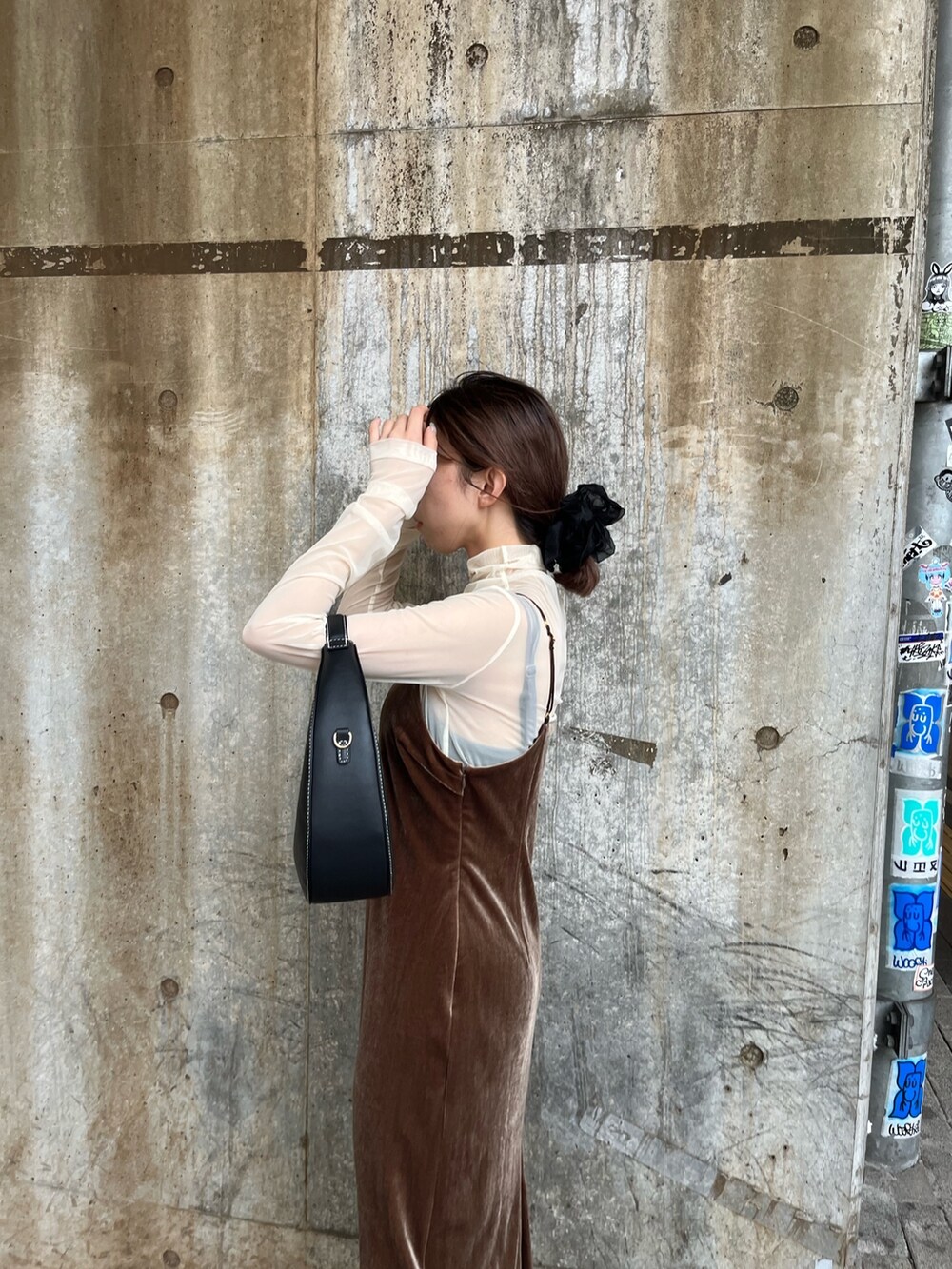 ブラウン系のワンピース、ブラック系のショルダーバッグ、ブラック系のブーツを着用したレディースの秋コーディネートの7枚目の写真