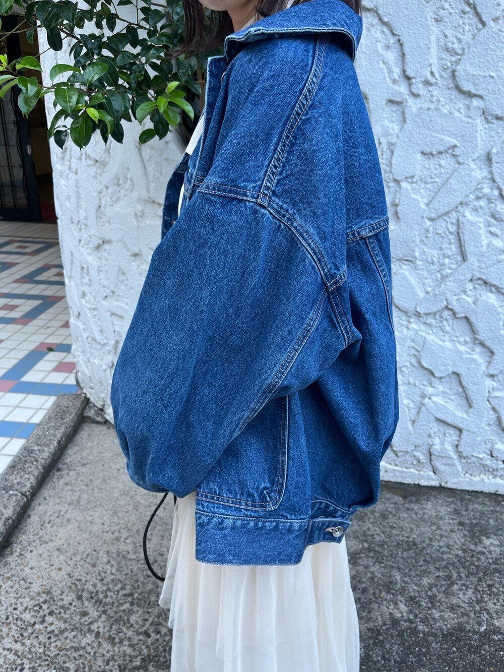 ホワイト系のスカート、ブルー系のデニムジャケット、ホワイト系のTシャツ/カットソーを着用したレディースの秋コーディネートの5枚目の写真