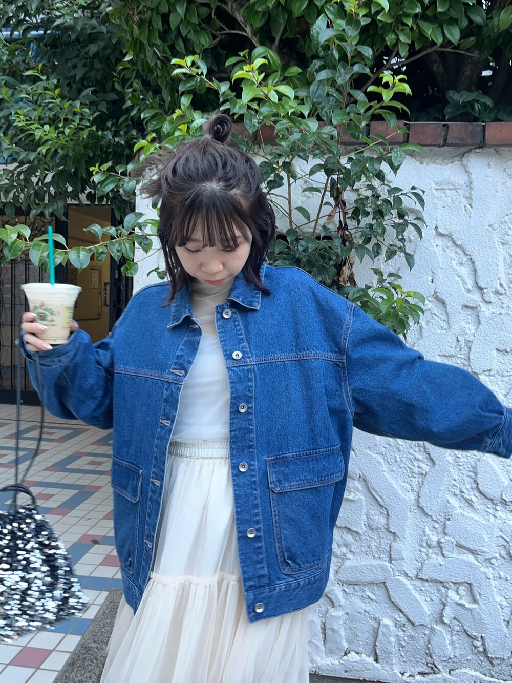 ホワイト系のスカート、ブルー系のデニムジャケット、ホワイト系のTシャツ/カットソーを着用したレディースの秋コーディネートの3枚目の写真