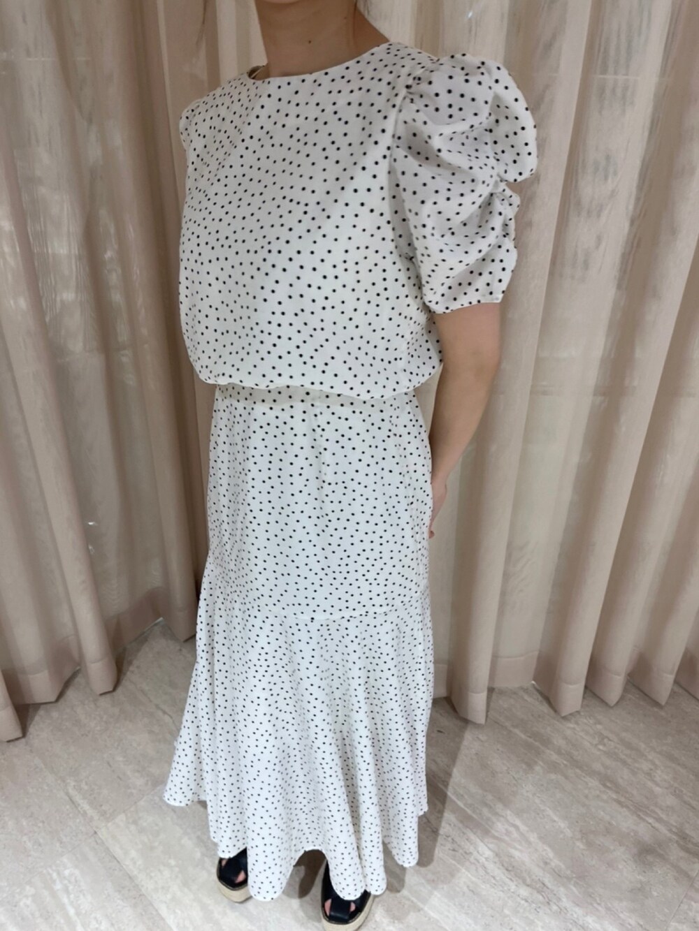 ホワイト系のワンピース、ブラック系のサンダルを着用したレディースの夏コーディネートの6枚目の写真