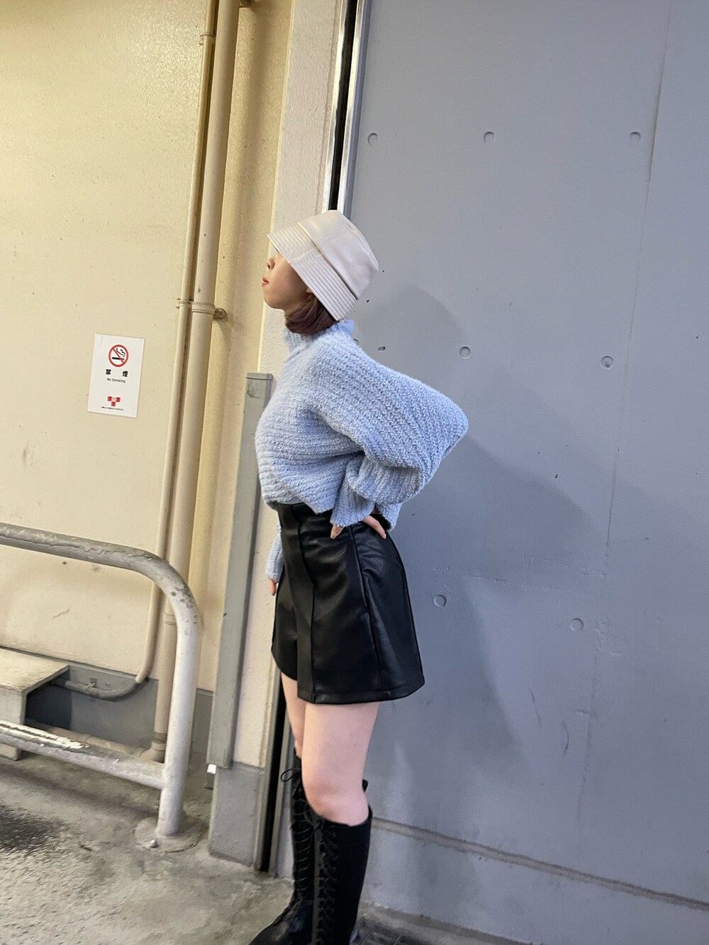 ブラック系のブーツ、ベージュ系のショルダーバッグ、ブルー系のニット/セーターを着用したレディースの冬コーディネートの2枚目の写真