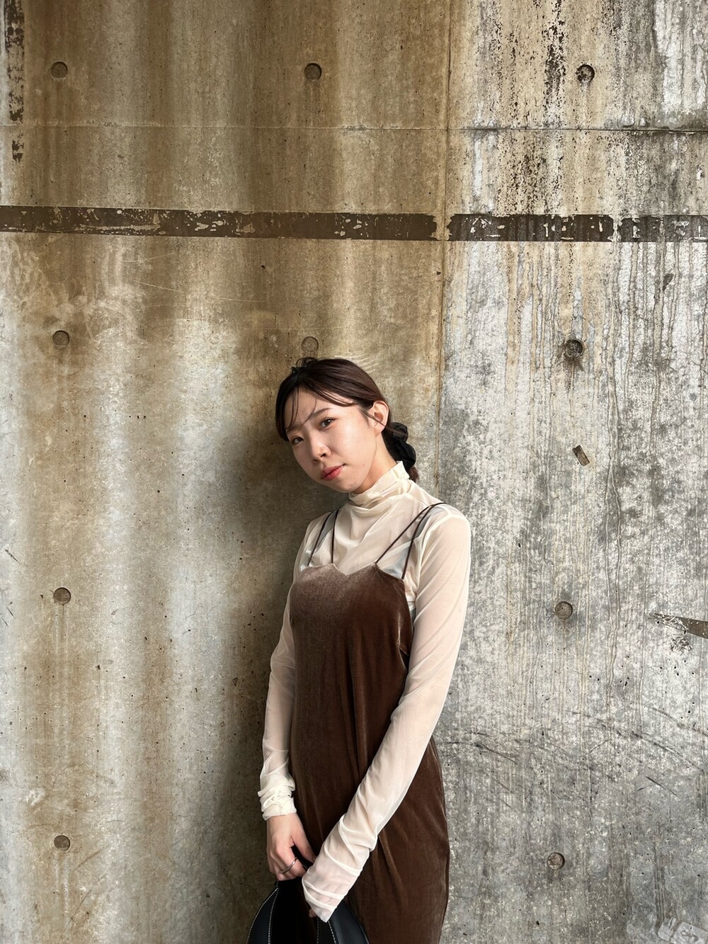 ブラウン系のワンピース、ブラック系のショルダーバッグ、ブラック系のブーツを着用したレディースの秋コーディネートの5枚目の写真