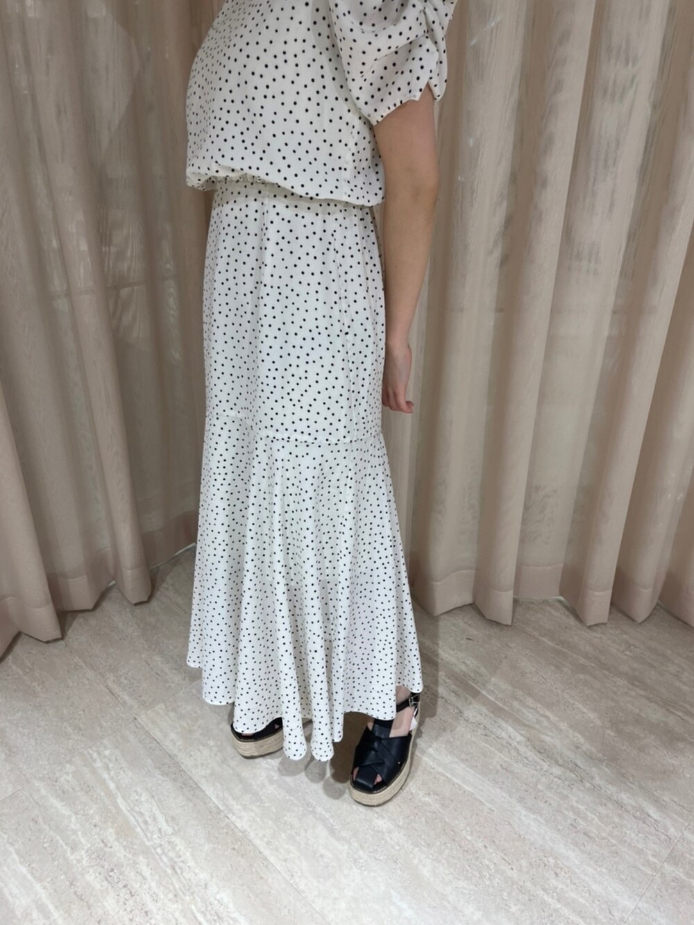 ホワイト系のワンピース、ブラック系のサンダルを着用したレディースの夏コーディネートの5枚目の写真