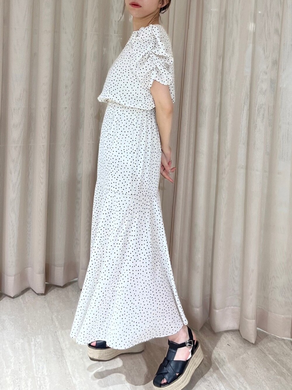 ホワイト系のワンピース、ブラック系のサンダルを着用したレディースの夏コーディネートの3枚目の写真