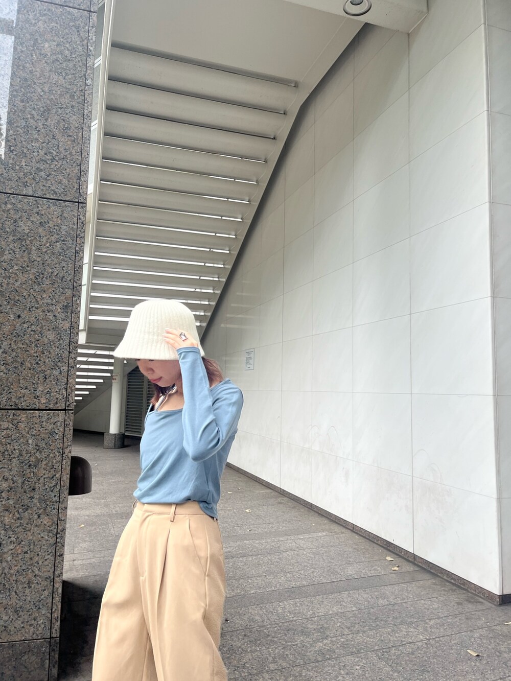 ブルー系のTシャツ/カットソー、ベージュ系のスラックス、ブラック系のバッグを着用したレディースの秋コーディネートの3枚目の写真